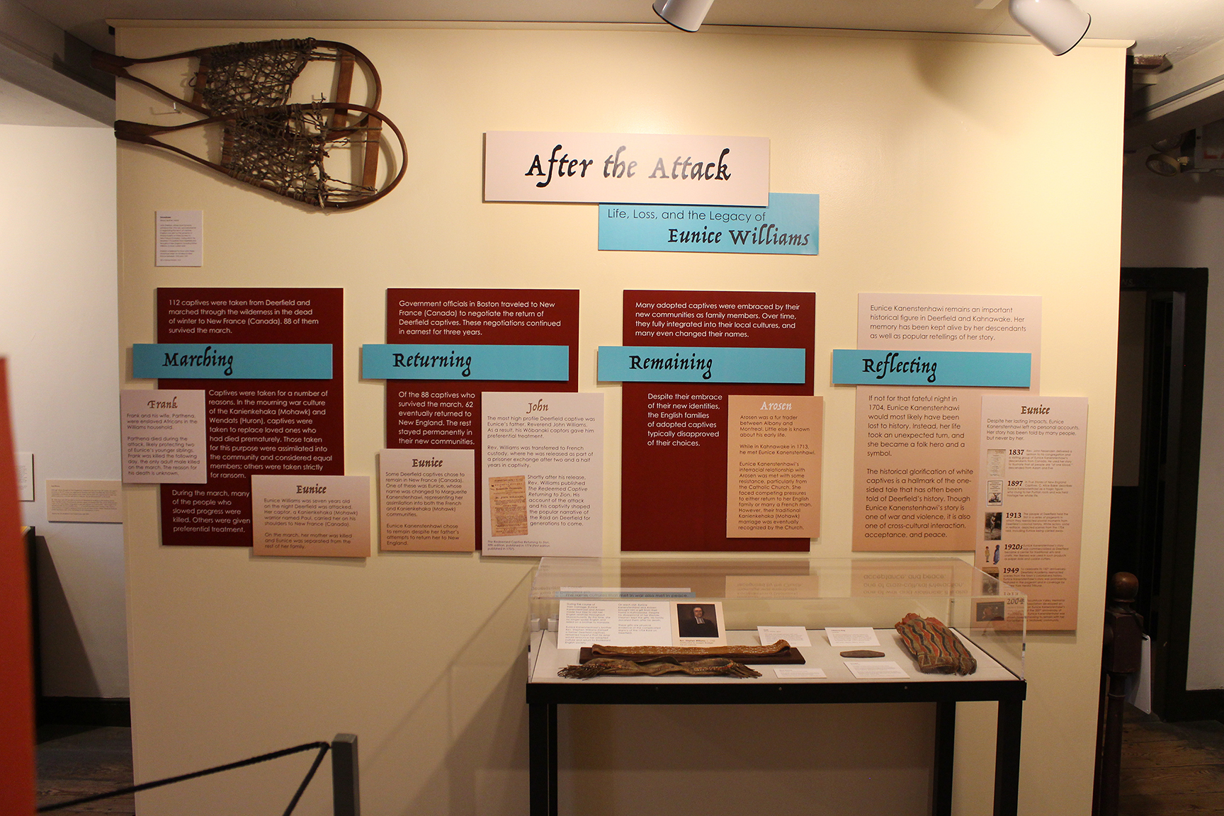 Exhibit wall featuring snowshoes and four indigenous gifts